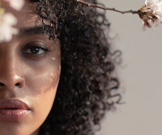 person in gray hoodie holding red and white box
